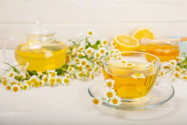 stock image Chamomile tea in a glass cup on a white texture background. Natural hour with chamomile flowers. Herbal tea. Immunity tea.Natural healer concept. Healthy detox drink.Close up. Place for text.