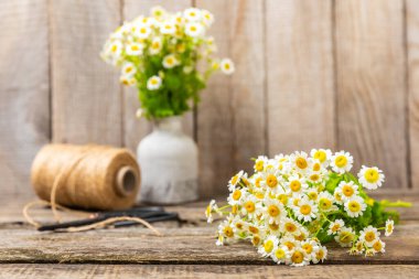 Bir buket papatya ve gri mermer beton vazo. Bahar-yaz kokulu bir buket yabani çiçek. Doku ahşap arka plan kompozisyonu. Biraz rahatla. mevsimsel bileşim.