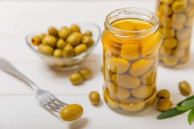 Cam kavanozda zeytin turşusu. Ahşap bir arka planda. Ahşap masada lezzetli zeytinler. Yakın plan. Lezzetli sağlıklı Akdeniz yemekleri. Vejetaryen.