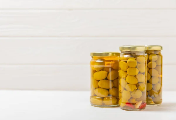 stock image Pickled olives in glass jar. On a wooden background.Tasty olives on wooden table.Close-up.Place for text.Copy space. Delicious healthy mediterranean food.Vegan