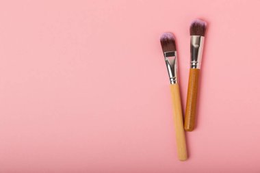 Pembe arka planda kozmetik makyaj fırçası. Makyaj için kozmetik ürün. Yaratıcı ve güzel moda konsepti. Moda. Kozmetik makyaj fırçası koleksiyonu, üst görüş, afiş. Mesaj için yer. MOCAP.
