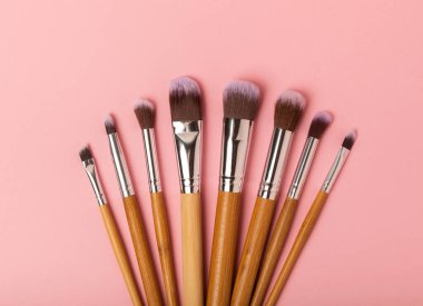 Pembe arka planda kozmetik makyaj fırçası. Makyaj için kozmetik ürün. Yaratıcı ve güzel moda konsepti. Moda. Kozmetik makyaj fırçası koleksiyonu, üst görüş, afiş. Mesaj için yer. MOCAP.