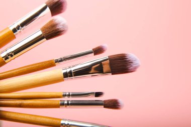 Pembe arka planda kozmetik makyaj fırçası. Makyaj için kozmetik ürün. Yaratıcı ve güzel moda konsepti. Moda. Kozmetik makyaj fırçası koleksiyonu, üst görüş, afiş. Mesaj için yer. MOCAP.