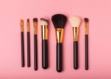 Pembe arka planda kozmetik makyaj fırçası. Makyaj için kozmetik ürün. Yaratıcı ve güzel moda konsepti. Moda. Kozmetik makyaj fırçası koleksiyonu, üst görüş, afiş. Mesaj için yer. MOCAP.