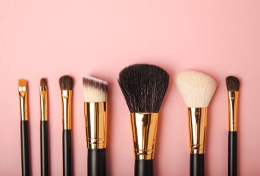 Pembe arka planda kozmetik makyaj fırçası. Makyaj için kozmetik ürün. Yaratıcı ve güzel moda konsepti. Moda. Kozmetik makyaj fırçası koleksiyonu, üst görüş, afiş. Mesaj için yer. MOCAP.