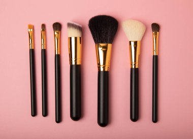 Pembe arka planda kozmetik makyaj fırçası. Makyaj için kozmetik ürün. Yaratıcı ve güzel moda konsepti. Moda. Kozmetik makyaj fırçası koleksiyonu, üst görüş, afiş. Mesaj için yer. MOCAP.