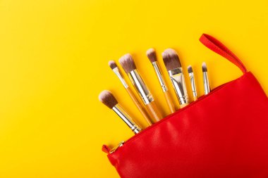 Sarı arka planda kozmetik makyaj fırçası. Makyaj için kozmetik ürün. Yaratıcı ve güzel moda konsepti. Moda. Kozmetik makyaj fırçası koleksiyonu, üst görüş, afiş. Mesaj için yer. MOCAP.