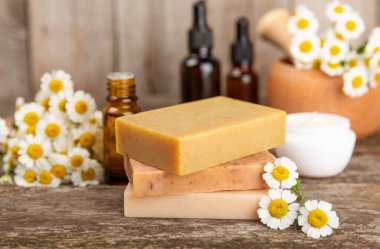 Papatya Spa 'sı. Temel yağ, deniz tuzu, papatya çiçeği, vücut kremi ve el yapımı sabun. Papatya çiçekli doğal bitkisel kozmetik. Dokulu bir arka plan. Güzellik konsepti. Kozmetik tüpü. 