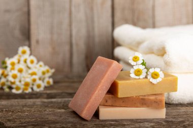 Klasik kahverengi ahşap üzerinde papatya çiçekleri olan doğal ev yapımı sabun. Spa prosedürü. Güzellik konsepti. Vücut bakımı. Uzayı kopyala Metin için yer.