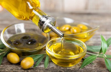 Kahverengi desenli arka planda bir şişede zeytin yağı. Zeytin dallı ve meyveli yağ şişesi. Mesaj için yer. kopyalama alanı. Yemek yağı ve salata sosu..