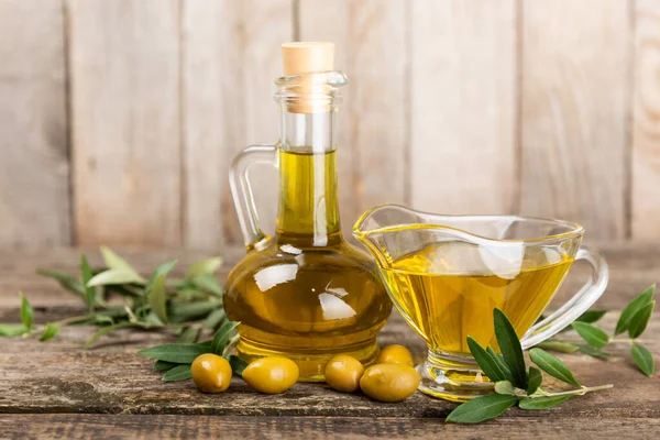 Olive oil in a bottle on a brown texture background. Oil bottle with branches and fruits of olives. Place for text. copy space. Cooking oil and salad dressing.