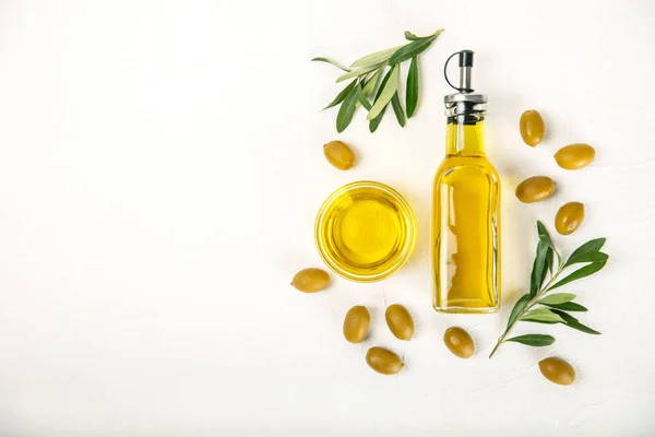 stock image Olive oil in a bottle on a white texture background. Oil bottle with branches and fruits of olives. Place for text. copy space. cooking oil and salad dressing