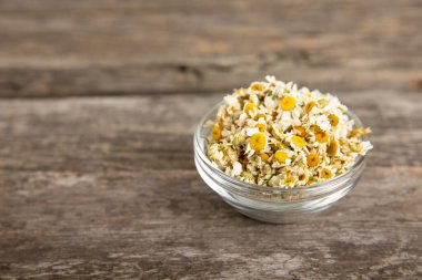 Papatya çayı, dokuma masasında bir kase içinde kurutulmuş papatya çayı. Papatya çayı. Papatya çayı. Düz yat. İçinde buket ve havan topu içinde papatya çiçeği olan bir kompozisyon. Bitkisel içecek. Rahatlatıcı ve tonik çay. 