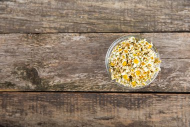 Papatya çayı, dokuma masasında bir kase içinde kurutulmuş papatya çayı. Papatya çayı. Papatya çayı. Düz yat. İçinde buket ve havan topu içinde papatya çiçeği olan bir kompozisyon. Bitkisel içecek. Rahatlatıcı ve tonik çay. 