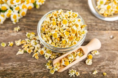 Papatya çayı, dokuma masasında bir kase içinde kurutulmuş papatya çayı. Papatya çayı. Papatya çayı. Düz yat. İçinde buket ve havan topu içinde papatya çiçeği olan bir kompozisyon. Bitkisel içecek. Rahatlatıcı ve tonik çay. 