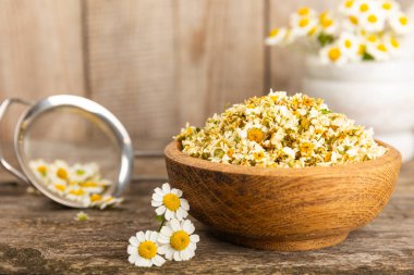 Papatya çayı, dokuma masasında bir kase içinde kurutulmuş papatya çayı. Papatya çayı. Papatya çayı. Düz yat. İçinde buket ve havan topu içinde papatya çiçeği olan bir kompozisyon. Bitkisel içecek. Rahatlatıcı ve tonik çay. 
