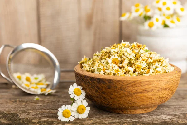 Papatya çayı, dokuma masasında bir kase içinde kurutulmuş papatya çayı. Papatya çayı. Papatya çayı. Düz yat. İçinde buket ve havan topu içinde papatya çiçeği olan bir kompozisyon. Bitkisel içecek. Rahatlatıcı ve tonik çay. 