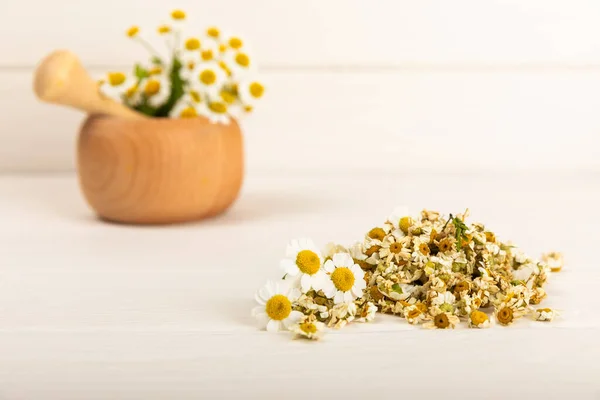 stock image Dried chamomile tea on texture table.dry chamomile. Chamomile tea. flat lay. Composition with a bouquet and chamomile inflorescences in a mortar. Herbal drink. Soothing and tonic tea. copy space.