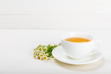 Çiçek tomurcuklu papatya çayı, beyaz ahşap bir masada bal ve limon ve bir buket papatya çayı. Yararlı bitkisel içecekler ve doğal iyileştirici konsept. Dokunulmazlık Çayı. Kapatın. Boşluğu kopyala.