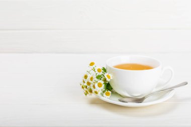 Çiçek tomurcuklu papatya çayı, beyaz ahşap bir masada bal ve limon ve bir buket papatya çayı. Yararlı bitkisel içecekler ve doğal iyileştirici konsept. Dokunulmazlık Çayı. Kapatın. Boşluğu kopyala.