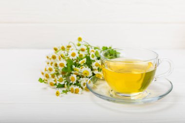 Çiçek tomurcuklu papatya çayı, beyaz ahşap bir masada bal ve limon ve bir buket papatya çayı. Yararlı bitkisel içecekler ve doğal iyileştirici konsept. Dokunulmazlık Çayı. Kapatın. Boşluğu kopyala.