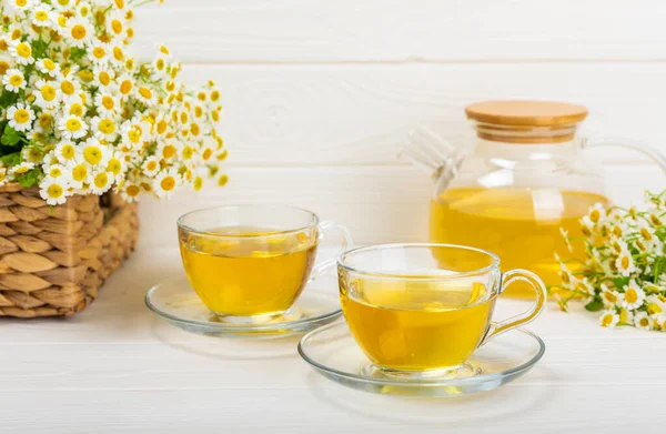 Çiçek tomurcuklu papatya çayı, beyaz ahşap bir masada bal ve limon ve bir buket papatya çayı. Yararlı bitkisel içecekler ve doğal iyileştirici konsept. Dokunulmazlık Çayı. Kapatın. Boşluğu kopyala.