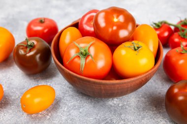 Mermer desenli domatesler. Çeri domatesleri, sarı, pembe, kahverengi ve siyah domatesler bir kasede. Organik sebzeler, hasat. Vejetaryen. Taze olgun domatesler. Boşluğu kopyala.