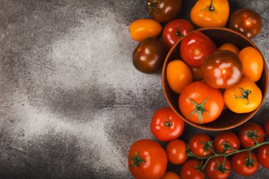 Mermer desenli domatesler. Çeri domatesleri, sarı, pembe, kahverengi ve siyah domatesler bir kasede. Organik sebzeler, hasat. Vejetaryen. Taze olgun domatesler. Boşluğu kopyala.