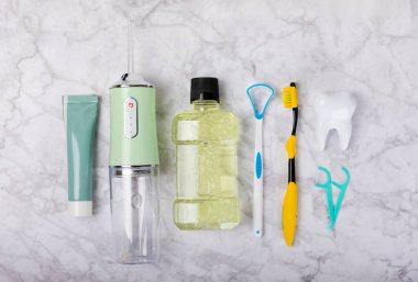 Elektronik ağız temizleyici, diş fırçası, macun, diş ipi ve ağız gargarası. Ağız hijyeni için diş aleti. Elektrikli İnterdental Temizleyici. Diş suyu banyosu. Oral bakım kavramı. 