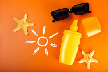 Turuncu arka planda güneş kremi. SPF kremi. Güneş koruması. Ultraviyole koruma. Yaz. Dinlenme ve tatil kavramı. Yaz havası. Tasarım. - Model. Alışveriş konsepti.