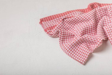 Hafif desenli arka planda mutfak havlusu. Mutfak aletleri ve tekstil peçetesi. Masada bir yığın pamuk havlu var. Ev dekoru. Masa örtüsü lütfen. Uzayı metin için kopyala. Tasarım için model. Düz yatıyordu..