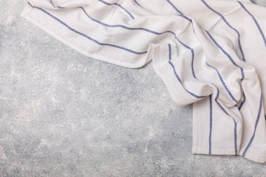 Hafif desenli arka planda mutfak havlusu. Mutfak aletleri ve tekstil peçetesi. Masada bir yığın pamuk havlu var. Ev dekoru. Masa örtüsü lütfen. Uzayı metin için kopyala. Tasarım için model. Düz yatıyordu..