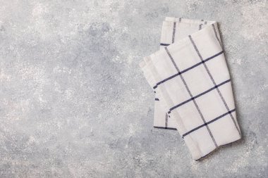 Hafif desenli arka planda mutfak havlusu. Mutfak aletleri ve tekstil peçetesi. Masada bir yığın pamuk havlu var. Ev dekoru. Masa örtüsü lütfen. Uzayı metin için kopyala. Tasarım için model. Düz yatıyordu..