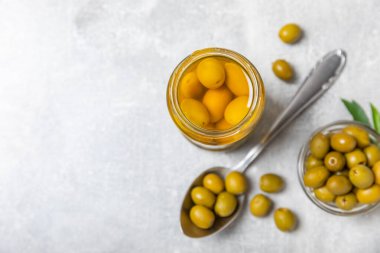 Lezzetli yeşil zeytinler. Cam kavanozda zeytin turşusu. Ahşap bir arka planda. Lezzetli zeytinler. Yakın plan. Vejetaryen. Mesaj için yer. Boşluğu kopyala.