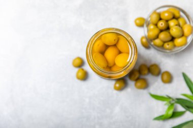 Lezzetli yeşil zeytinler. Cam kavanozda zeytin turşusu. Ahşap bir arka planda. Lezzetli zeytinler. Yakın plan. Vejetaryen. Mesaj için yer. Boşluğu kopyala.