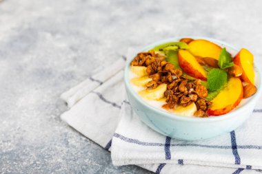 Bir kase granola yoğurt ve dokuma masasında taze böğürtlen. Yoğurt böğürtlen, acai kasesi, spirulina kasesi. Sağlıklı yemek, dengeli kahvaltı. Çilek, yabanmersini, kivi, şeftali, badem ve chia..