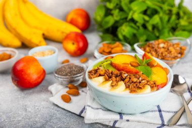 Bir kase granola yoğurt ve dokuma masasında taze böğürtlen. Yoğurt böğürtlen, acai kasesi, spirulina kasesi. Sağlıklı yemek, dengeli kahvaltı. Çilek, yabanmersini, kivi, şeftali, badem ve chia..