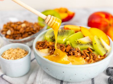 Bir kase granola yoğurt ve dokuma masasında taze böğürtlen. Yoğurt böğürtlen, acai kasesi, spirulina kasesi. Sağlıklı yemek, dengeli kahvaltı. Çilek, yabanmersini, kivi, şeftali, badem ve chia..