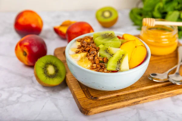 Bir kase granola yoğurt ve dokuma masasında taze böğürtlen. Yoğurt böğürtlen, acai kasesi, spirulina kasesi. Sağlıklı yemek, dengeli kahvaltı. Çilek, yabanmersini, kivi, şeftali, badem ve chia..