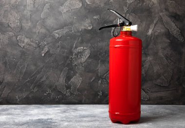 Siyah doku arka planında yangın söndürücü. Yangın koruması, ev yangını söndürücü. Ev güvenliği kavramı. Mesaj için yer. Boşluğu kopyala. Pankart
