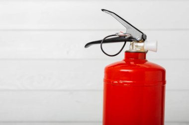 Beyaz dokuda yangın söndürücü var. Yangın koruması, ev yangını söndürücü. Ev güvenliği kavramı. Mesaj için yer. Boşluğu kopyala. Pankart