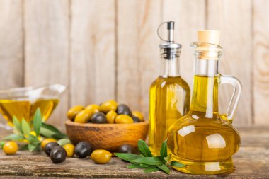 Beyaz arka planda izole edilmiş bir şişede zeytin yağı. Zeytin dallı ve meyveli yağ şişesi. sebze yağı ve salata sosu..