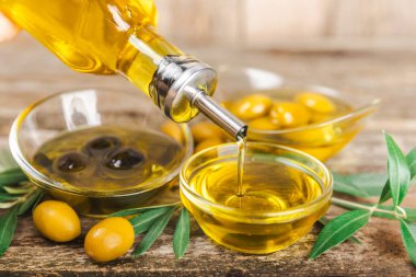 Beyaz arka planda izole edilmiş bir şişede zeytin yağı. Zeytin dallı ve meyveli yağ şişesi. sebze yağı ve salata sosu..
