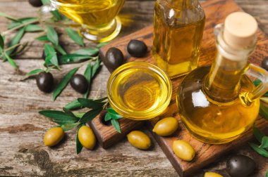 Beyaz arka planda izole edilmiş bir şişede zeytin yağı. Zeytin dallı ve meyveli yağ şişesi. sebze yağı ve salata sosu..