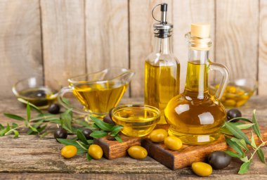 Beyaz arka planda izole edilmiş bir şişede zeytin yağı. Zeytin dallı ve meyveli yağ şişesi. sebze yağı ve salata sosu..