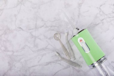 Mermer zemin üzerinde elektronik ağız sulandırıcı. Ağız hijyeni için diş aleti. Elektrikli İnterdental Temizleyici. Diş suyu banyosu. Oral bakım konsepti. Mesaj için yer. Boşluğu kopyala.