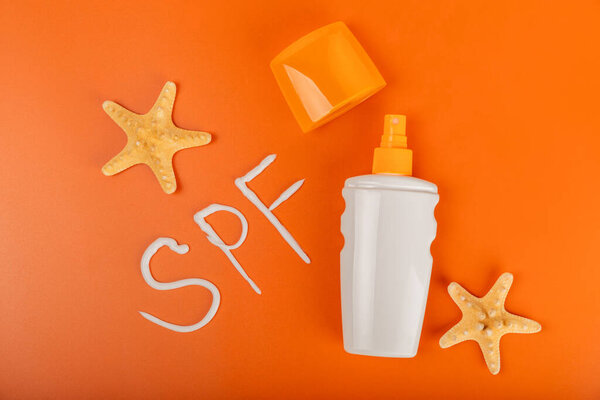 Крем от солнца. Банка, косметическая трубка с SPF кремом на ярко-оранжевом фоне. Концепция ухода за кожей и защиты от ультрафиолетовых лучей. Фотографирую. Выбор sunscreen.place для text.copy пространства.