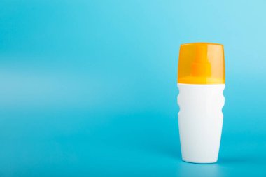 Güneş kremi. Kavanoz, parlak mavi arka planda SPF kremi ile kozmetik tüp. Cilt bakımı ve ultraviyole ışınlardan korunma kavramı. Fotoğrafçılık. Güneş kremi seçimi. Metin için yer. Boşluğu kopyala.