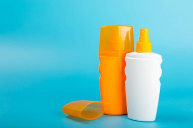 Güneş kremi. Kavanoz, parlak mavi arka planda SPF kremi ile kozmetik tüp. Cilt bakımı ve ultraviyole ışınlardan korunma kavramı. Fotoğrafçılık. Güneş kremi seçimi. Metin için yer. Boşluğu kopyala.