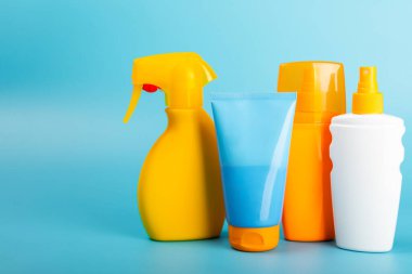 Güneş kremi. Kavanoz, parlak mavi arka planda SPF kremi ile kozmetik tüp. Cilt bakımı ve ultraviyole ışınlardan korunma kavramı. Fotoğrafçılık. Güneş kremi seçimi. Metin için yer. Boşluğu kopyala.